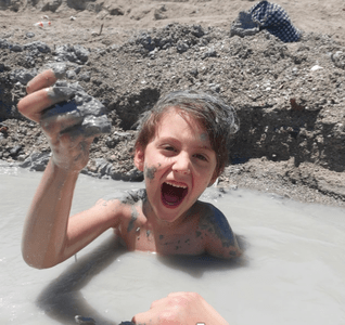 Un enfant jouant avec la boue de la mer Morte
